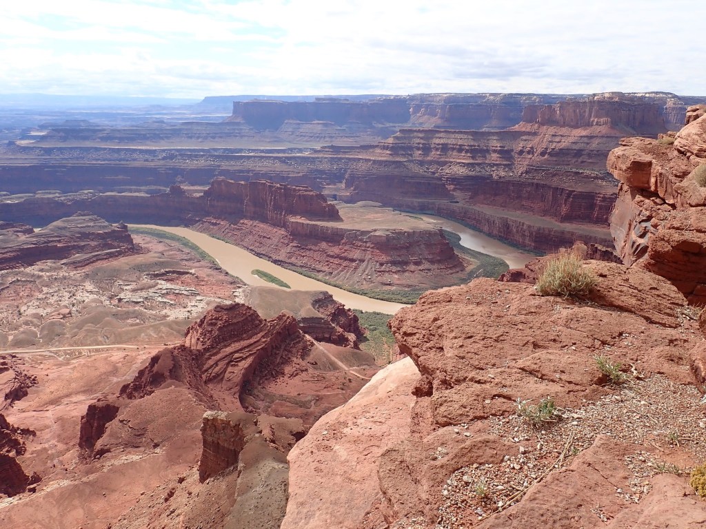 Photo of a huge, colorful canyon like the Grand Canyon, with the Colorado River curving through it.