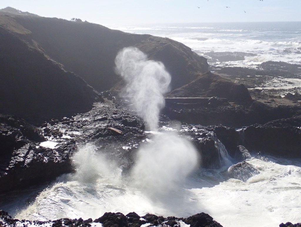 Waves roll into the rock formation known as Spouting Horn and spray up like a geyser.