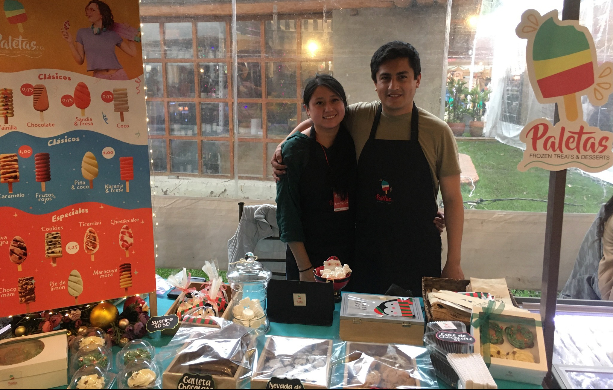 photo of a smiling couple selling baked goods and frozen treats