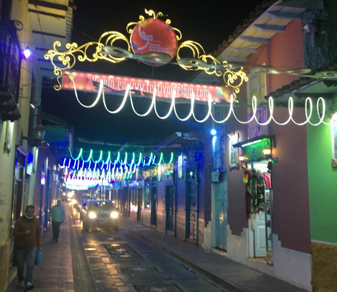 photo of a colorful, festively lit, narrow street at night