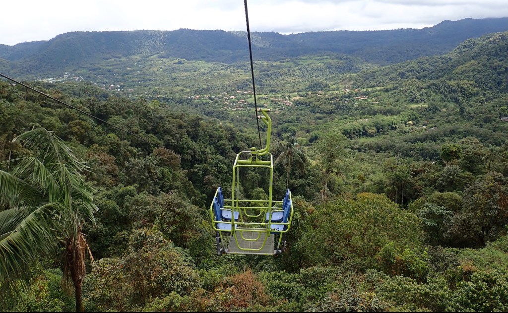A photo of the town of Mindo in the background and the Teleférica chairlift, which soars above the Mindo valley amid cloud forest peaks.