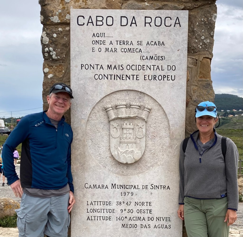 photo of Al and Rachel standing next to a sign that says Cabo Da Roca, Ponta Mais Ocidental Do Continente Europeu (in Portuguese)
