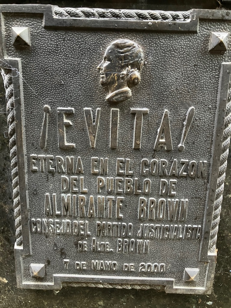 photo of a bronze plaque saying EVITA! and a caption in Spanish saying "eternally in the heart"