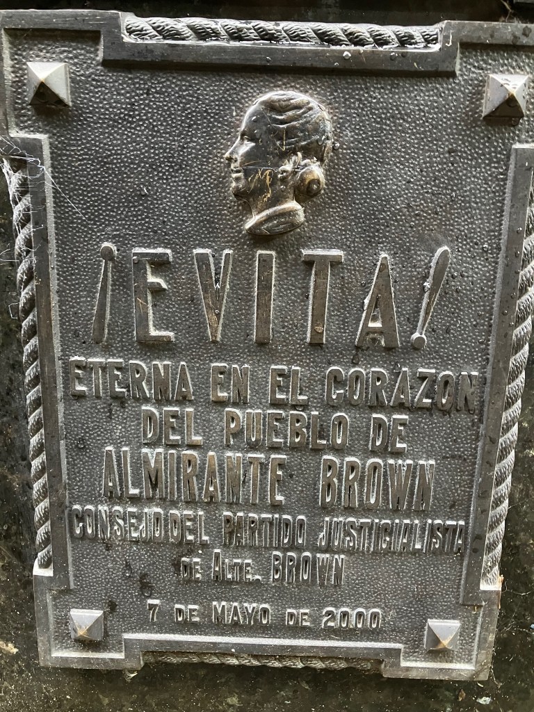 photo of a bronze plaque saying EVITA! and a caption in Spanish saying "eternally in the heart"