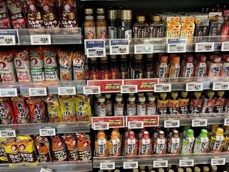 photo of four grocery shelves stocked full of bottles and packages labeled in Japanese